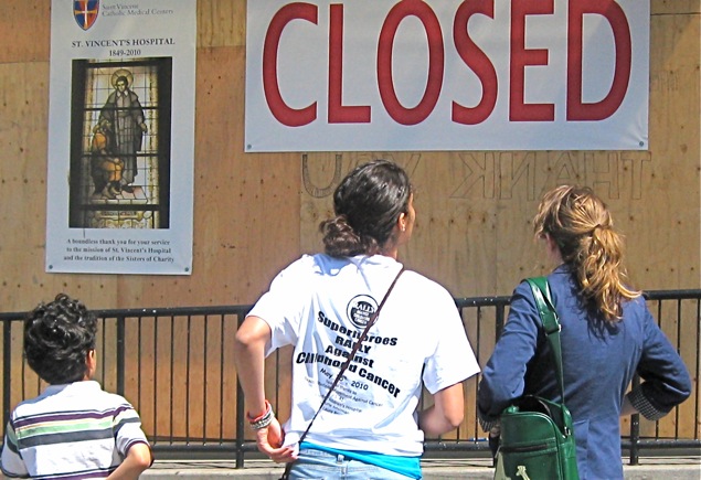 People looking at "Closed" sign on building.